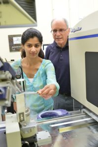 Student performing experiment while faculty observes
